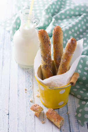 Homemade breadsticks with poppy seeds on blue backgroundの写真素材