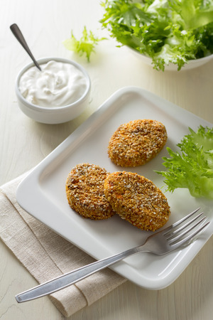 Healthy vegetable cutlets with carrot, dried apricots, almonds and herbs, breaded in oat branの写真素材