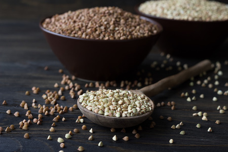 Green and brown buckwheat on a wooden surfaceの写真素材