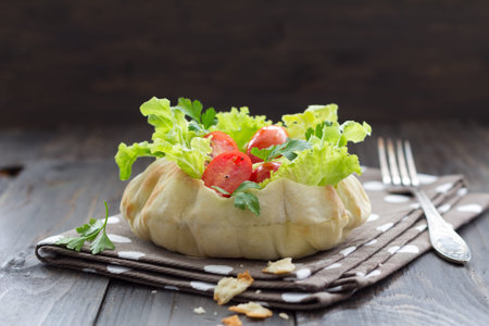 Salad in a bread bowl on a wooden table, selective focusの写真素材