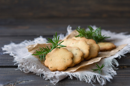 Delicious freshly baked homemade cookies with rosemary on a wooden surface, rustic style, selective focusの写真素材