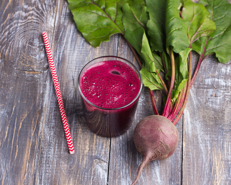Fresh beet in a glass with a straw on a wooden background, selective focus. Healthy detox dietの写真素材