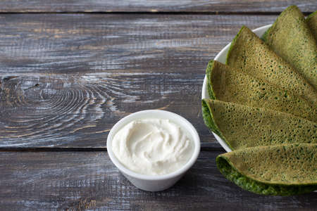 Spinach pancakes on a white plate on a wooden table, free space, selective focus. Delicious healthy breakfastの写真素材
