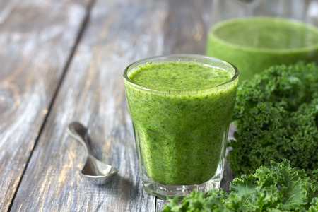 Green smoothies with kale, banana and lemon. on a wooden table. selective focus. free space. healthy diet foodの写真素材