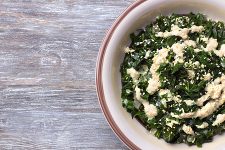 Stewed kale with tahini sauce and sesame seeds. top view. free space. healthy diet foodの写真素材