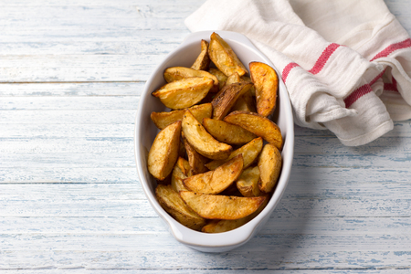 Baked potatoes on a light blue background, selective focus. Delicious vegan homemade foodの写真素材