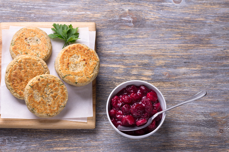 Bean cutlets with herbs, spices, berry sauce on a wooden board on a wooden table, rustic style, top view, free space. Delicious vegetarian foodの写真素材