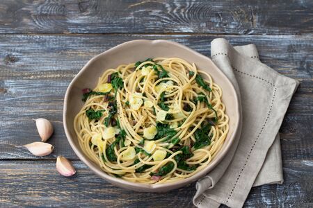 Vegan spaghetti with chard and garlic on a wooden table. Delicious homemade foodの写真素材
