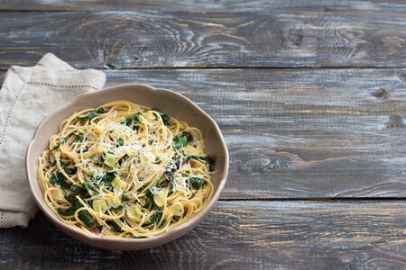 Delicious spaghetti with chard, garlic and cheese on a wooden table. Simple homemade foodの写真素材