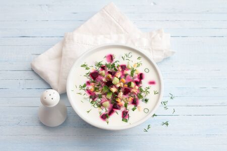 Delicious summer soup, beetroot soup (svekolnik, holodnik) on kefir, with cucumber, boiled eggs and greens. traditional Lithuanian, Russian, Ukrainian, Belorussian or Polish cuisine. healthy homemade food. on a wooden table. top viewの写真素材