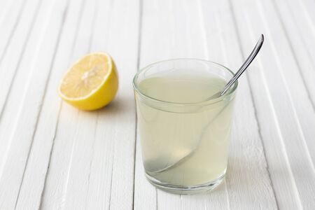 Lemon water in a glass on a white background. selective focus. healthy morning drinkの写真素材