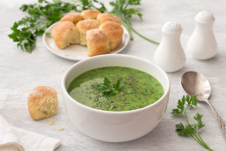 Healthy green kale cream soup with potatoes and bread on gray background with free space. simple...