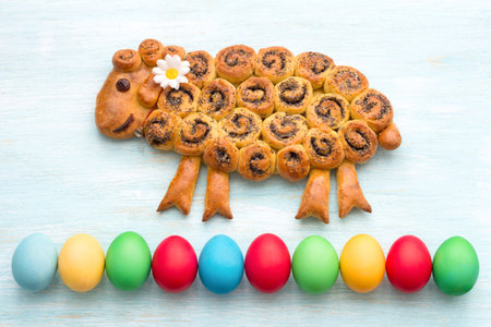 Easter lamb cake with poppy seeds, colorful eggs on a blue background. freshly baked homemade...