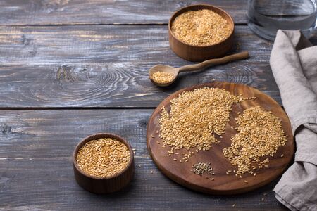 Golden flax seeds on wooden table. trash removal process. healthy vegan superfood. space, horizontalの写真素材