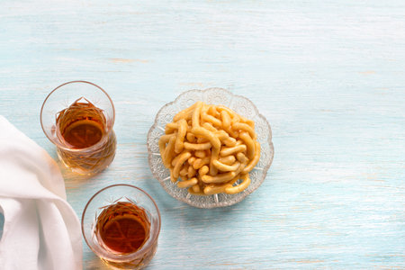 Chak chak, pieces of dough in honey, tatar traditional dessert on light blue background, top view,...