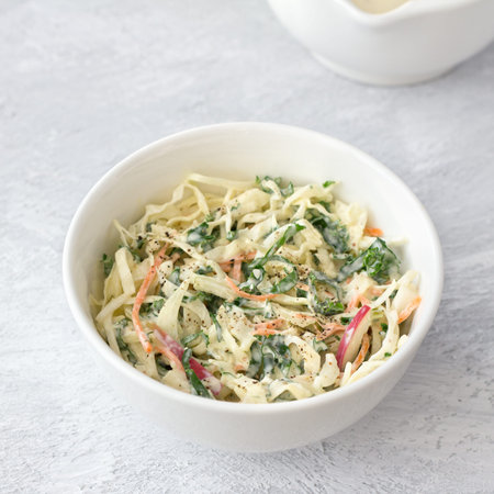 Homemade healthy cole slow salad with kale in white bowl on gray textured background, top viewの写真素材