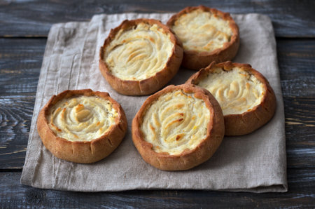 Traditional christmas russian rye pies "kalitki" or "koliadki" stuffed with potatoes on wooden backgroundの写真素材