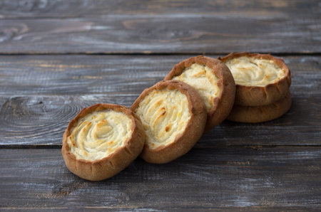 Traditional christmas russian rye pies kalitki or koliadki stuffed with potatoes on wooden...