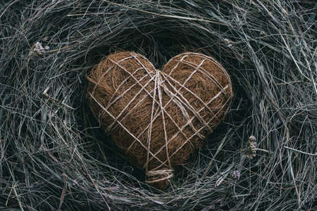 Straw heart on natural straw background, rustic style, top view, tonedの写真素材