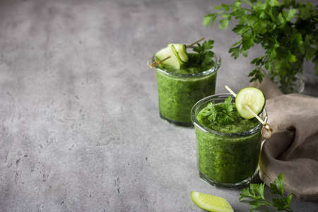 Freshly cooked parsley smoothie with cucumber on a gray concrete background, selective focus, copy space. Homemade healthy food conceptの写真素材