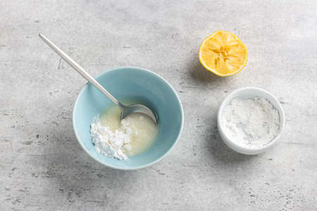 Cooking sugar icing for baking from powdered sugar and lemon juiceの写真素材