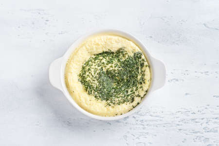 A white baking dish with a cooked omelette after steaming on a light blue background. Cooking omelette, homemade healthy foodの写真素材