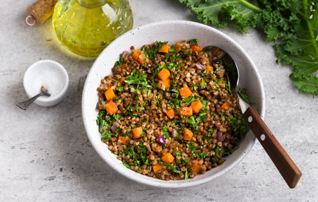Buckwheat with vegetables and kale on a gray textured background, top view. Delicious healthy vegan food.の写真素材