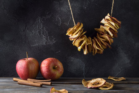 Homemade dried apples with cinnamon, apple chips on a wooden background. Delicious healthy snackの写真素材