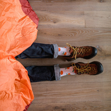 Feet in happy socks. Man is relaxing near tent and warming up his feet in happy socks.