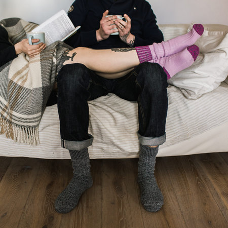 Pair in woollen socks with a cup of teaの写真素材
