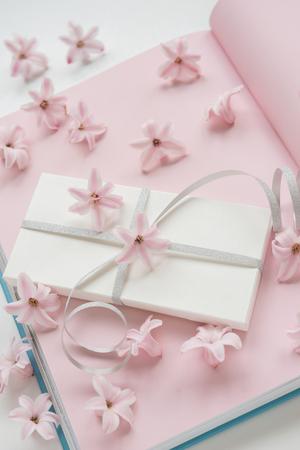 Flowers composition of pink flowers hyacinth with gift box and book on a pink background.Top view. Flat lay.の写真素材