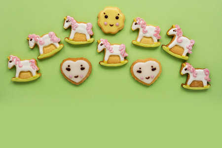 Unicorn and heart shaped sugar cookies decorated with pastel royal icing on pink backgroundの写真素材