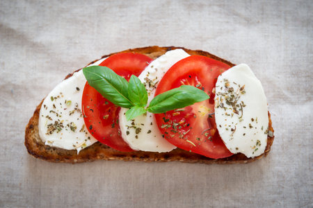 Toast with mozzarella cheese and fresh tomatoes with young basil