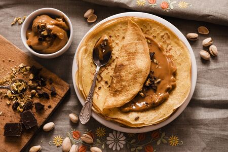 Thin Crepes with Butterscotch and almonds and chopped chocolateの写真素材