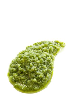 Pesto spread for blob isolated on white background. Green italian homemade spilled sauce made of ground basil, garlic, pine seeds, olives and pecorino sardo cheese. Top viewの写真素材