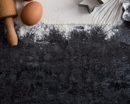 Baking ingredients for christmas cookies on dark background. Kitchen food frame. Free space for textの写真素材