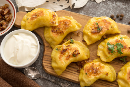 Yellow dumplings with turmeric, fried onions and parsley, stuffed with potatoes and soft feta...