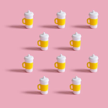Pattern of toy coffee cups on a pink background. Minimalism concept, 80s style.の写真素材