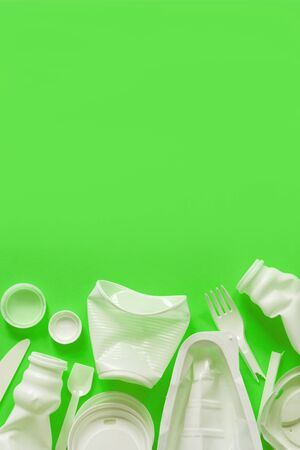 Used white plastic packaging for food on a lime green background. The concept of protecting the environment from plastic waste contamination. Flat layの写真素材