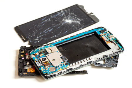 Old broken phone that cannot be repaired, disassembled for parts, isolated on white background