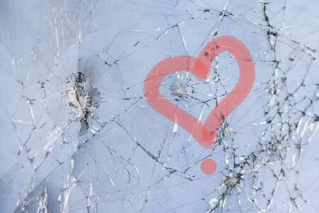 Red outline of a heart on a cracked touch screen phoneの写真素材
