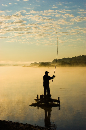 The fisherman fishes around in the morning at sunriseの写真素材