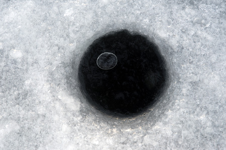 Hole for winter fishing in the afternoonの写真素材