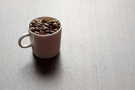 coffee grains in a white mug on a tableの写真素材