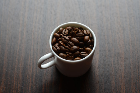 coffee grains in a white mug on a tableの写真素材