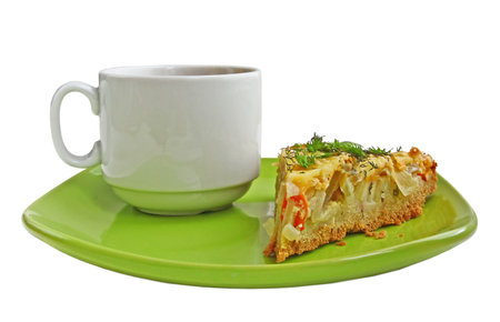 White cup with the piece of vegetable pie it is isolated on a green dishの写真素材