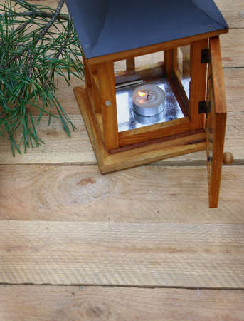 Wooden lantern with a conflagrant candle on wooden background の写真素材