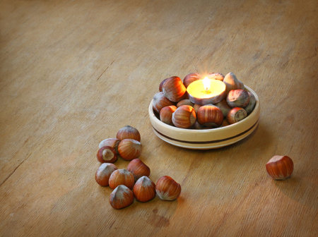 Conflagrant candle and hazel on a wooden table