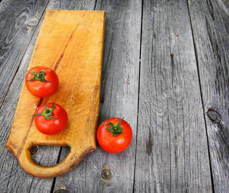 Red tomato on the board  on the kitchen vintage tableの写真素材