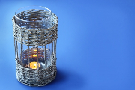 Age-old wattled lamp  a with a burning candle on a dark blue backgroundの写真素材